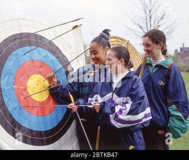 Ragazze studentesche che controllano l'obiettivo dell'arciera, Surrey, Inghilterra, Regno Unito Foto Stock