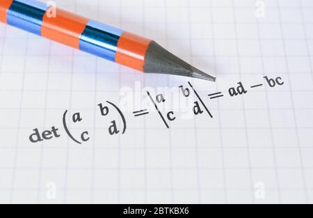 Matita e calcolo del determinante di una matrice su sfondo luminoso Foto Stock