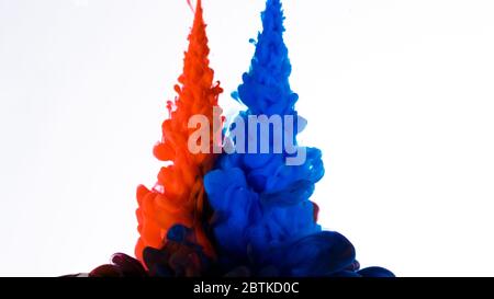Nuvola di inchiostro colorato in acqua isolata su bianco. Design astratto e struttura blu e rosso. Foto Stock
