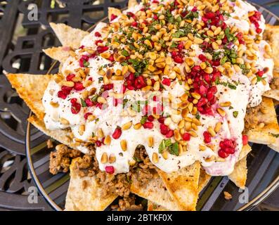 Un piatto di manzo e di melanzana fatteh, un piatto tradizionale medio orientale di pezzetti tostati di pane piatto con melanzane e manzo e yogurt Foto Stock