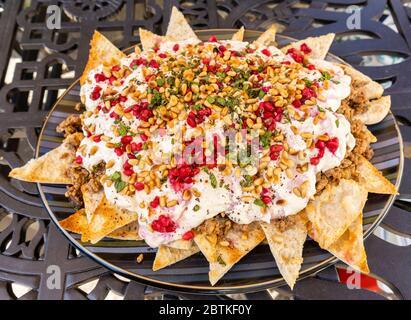 Un piatto di manzo e di melanzana fatteh, un piatto tradizionale medio orientale di pezzetti tostati di pane piatto con melanzane e manzo e yogurt Foto Stock