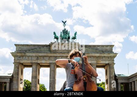 Berlino, Germania. 26 Maggio 2020. Un musicista suona violoncello di fronte alla porta di Brandeburgo a Berlino, capitale della Germania, il 26 maggio 2020. Il governo federale tedesco e i 16 stati hanno accettato in linea di principio di mantenere in vigore le restrizioni di contatto del coronavirus fino al 29 giugno, l'Ufficio federale della stampa ha annunciato martedì notte. Credit: Binh Truong/Xinhua/Alamy Live News Foto Stock