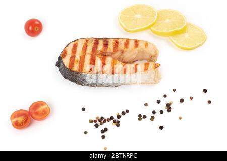 Bistecca di salmone alla griglia con limone e pomodori isolati su sfondo bianco. Foto Stock