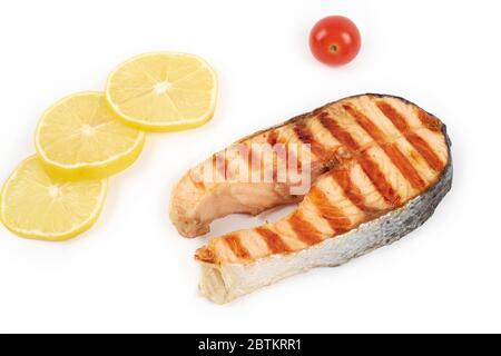 Bistecca di salmone alla griglia con limone e pomodori isolati su sfondo bianco. Foto Stock