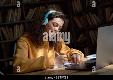 Studente ispanico teen girl scuola con cuffie distanza elearning online. Foto Stock