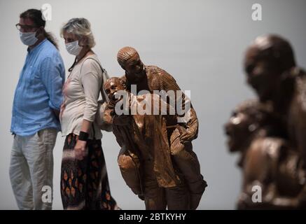 Malaga, Spagna. 26 Maggio 2020. Una coppia indossa maschere per il viso come precauzione, passando davanti a una scultura durante la mostra."da Miro a Barcelo" una mostra al Centro Museo Pompidou dopo la riapertura di diversi importanti musei, garantendo misure di sicurezza come maschere facciali, disinfettanti e scansioni di temperatura agli ingressi del museo. Credit: SOPA Images Limited/Alamy Live News Foto Stock