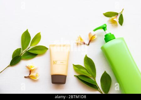 crema solare spf50 cosmetici cura della salute per la pelle viso, lozione corpo e fiori gialli frangipani di stile di vita donna relax in estate stagione Foto Stock