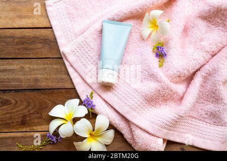 idratante schiuma detergente cosmetici bellezza estratto erbe cura della salute per lavare la pelle faccia con asciugamano viso di stile di vita donna su sfondo legno Foto Stock