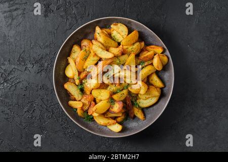 Piatto con spicchi di patate arrosto Foto Stock