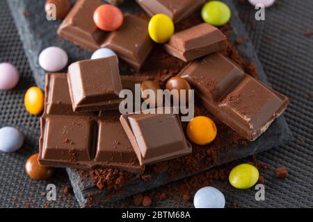 once di cioccolato e di tartarughe mescolate su un fondo di polvere di cacao Foto Stock