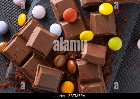 once di cioccolato e di tartarughe mescolate su un fondo di polvere di cacao Foto Stock