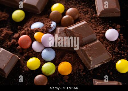 once di cioccolato e di tartarughe mescolate su un fondo di polvere di cacao Foto Stock