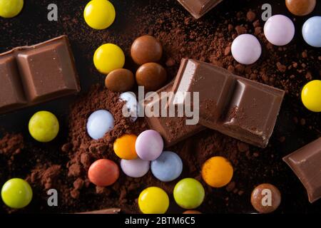 once di cioccolato e di tartarughe mescolate su un fondo di polvere di cacao Foto Stock