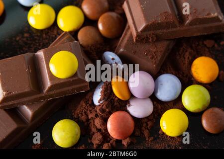 once di cioccolato e di tartarughe mescolate su un fondo di polvere di cacao Foto Stock