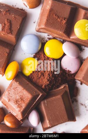 once di cioccolato e di tartarughe mescolate su un fondo di polvere di cacao Foto Stock