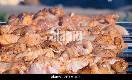 Friggiamo i kebab di shish, barbecue, barbecue nel cortile in estate in un fine settimana. Lo chef prepara carne in un bar o ristorante. Fresco crudo e fritto por Foto Stock