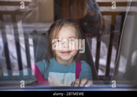 Mamma fotografa sua figlia attraverso la finestra. Riflessi stile di vita. Emozioni positive. Foto Stock