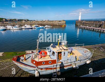 Newhaven, Edimburgo, Scozia, Regno Unito, 27 maggio 2020. UK Meteo: Le barche da pesca ormeggiate nelle acque calme del porto creano riflessi con una barca sul porto Foto Stock