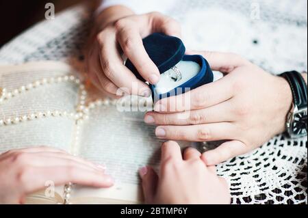 Un uomo propone e tenendo su un anello di fidanzamento Foto Stock