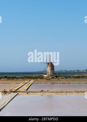 un antico mulino a vento e saline in sicilia Foto Stock