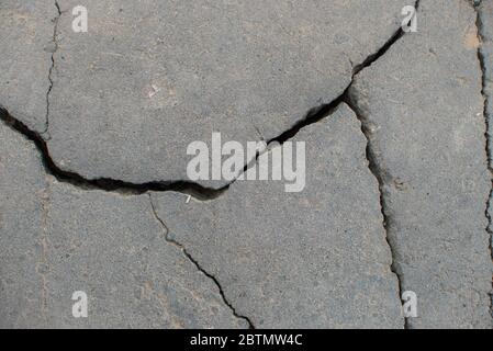 Asfalto grigio incrinato sulla strada. Texture di sfondo per la progettazione e la modellazione Foto Stock