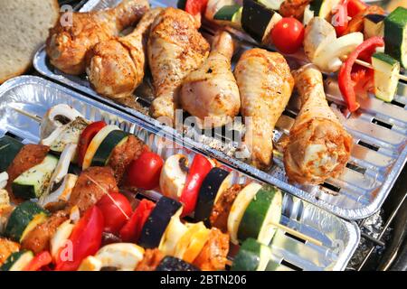 Cosce di pollo e spiedini di verdure grigliate al barbecue Foto Stock