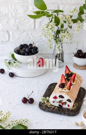 Meringa con frutti di pralina al pistacchio fresco e panna montata e crema di formaggio a cagliata. Dessert estivo Foto Stock