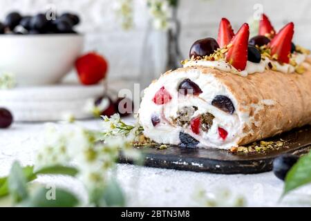 Meringa con frutti di pralina al pistacchio fresco e panna montata e crema di formaggio a cagliata. Dessert estivo Foto Stock