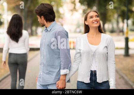 Ragazzo guardando altre donne a piedi con la ragazza a Park Foto Stock