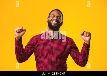 Felice uomo nero trionfante con mani sollevate Foto Stock