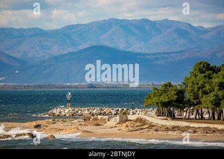 Spiaggia panoramica con piccola stazione meteo, pini e gabbiano volante. Fine autunno incredibile giornata di sole vicino al villaggio di Fanari, regione di Xanthi, Grecia del Nord. Montagna maestosa sullo sfondo Foto Stock