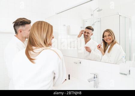 Donna in asciugamano grigio nella doccia con una spazzola per massaggio in legno  per pulire la pelle Foto stock - Alamy