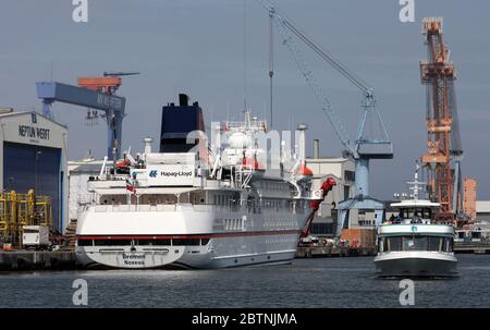 Rostock, Germania. 27 maggio 2020. La nave da spedizione Brema è ormeggiata nella città anseatica. Questa è la prima volta che una nave da crociera attraccava quest'anno. Sul lato destro potete vedere una nave escursione durante il tour del porto. Tuttavia, non ci sono passeggeri a bordo della nave che appartiene alla compagnia di navigazione Hapag-Lloyd Cruises, ma 71 membri dell'equipaggio. La nave sarà inizialmente ormeggiata al molo Maritim nel quartiere di Groß-Klein prima di intraprendere il suo prossimo viaggio regolare con un massimo di 155 passeggeri. Credit: Bernd Wüstneck/dpa-Zentralbild/dpa/Alamy Live News Foto Stock