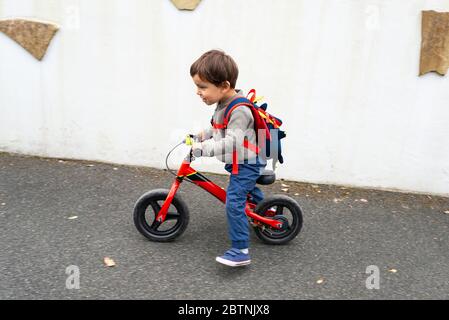 Il ragazzino guida la sua bici di equilibrio Foto Stock