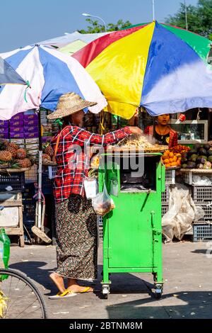 Una donna vende cibo di strada ad UNA stazione degli autobus vicino a Bagan, Regione di Mandalay, Myanmar. Foto Stock