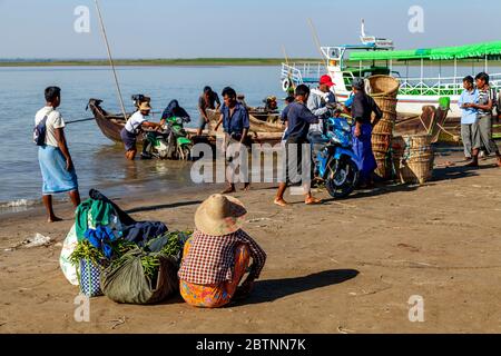 Merci e Moto che vengono scaricati da UNA barca sul fiume Irrawaddy, (Ayeyarwady), Bagan, Regione Mandalay, Myanmar. Foto Stock