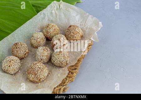 I morsi energetici senza cottura sono fatti con ingredienti - noci, cacao, cioccolato, avena e semi di sesamo. Su sfondo grigio. Foto Stock