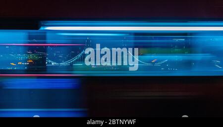 Tower Bridge di notte, incorniciato tra il blu di movimento di un autobus di Londra in rapido movimento. Foto Stock