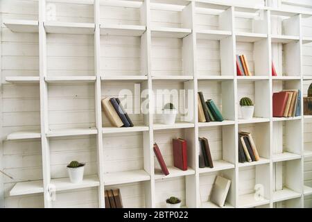 Ripiani in legno bianco con libri antichi. Libreria in legno. Foto Stock