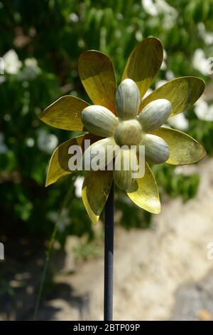 mulino a vento da giardino metallico giallo-oro in un giardino con vista ravvicinata Foto Stock