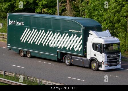 John Lewis; camion di consegna di trasporto, camion verde articolato, trasporto, camion, Cargo cargo, high-end grandi magazzini veicolo, trasporto commerciale europeo HGV, M6 a Manchester, Regno Unito Foto Stock