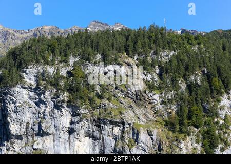 Massiccio pendio di montagna rocciosa che è parzialmente boschiva. Si trova in montagna alpina vicino a Lauterbrunnen in Svizzera Foto Stock