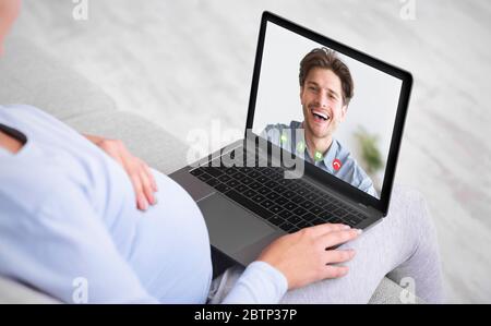 Ragazza che effettua videochiamate su un computer portatile all'aperto, chiacchierando con l'uomo Foto Stock