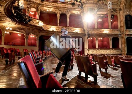 Dpatop - 27 maggio 2020, Berlino: Un dipendente trasporta le sedie dalle file di posti nell'auditorium del Berliner Ensemble. A causa delle restrizioni di contatto durante la pandemia della corona, i posti individuali saranno rimossi per le prestazioni future. Foto: Britta Pedersen/dpa-Zentralbild/dpa Foto Stock