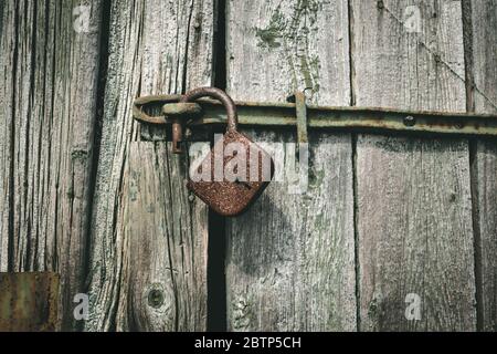 vecchio lucchetto arrugginito su porta in legno. serratura vintage aperta. concetto di protezione di sicurezza Foto Stock