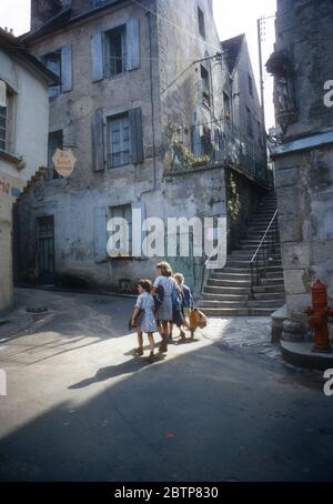 Bambini che camminano attraverso il centro storico di Clamecy, Francia, nella foto del 1967 Foto Stock