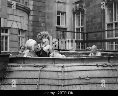 Bagni sopra il traffico Piccadilly . Una piscina è stata collocata sul balcone terrazzato dell'hotel Piccadilly e i bagnanti si tuffano nell'acqua appena sopra il traffico stradale. Bagnanti nella piscina sopra la strada. 3 agosto 1932 Foto Stock