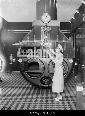 Apertura della mostra lavanderia . La Mostra Internazionale della lavanderia e dei commerci alleati è stata inaugurata presso la Royal Agricultural Hall , Islington , Londra . Foto mostra donna che esamina caldaia gigante 7 maggio 1934 Foto Stock