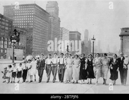 La più grande famiglia di Chicago . La famiglia Latora di Chicago , USA , è stata dichiarata la più grande famiglia di parentaggi italiani negli Stati Uniti . Quando la famiglia fu portata in un viaggio intorno al secolo di mostra di progresso cinque tassicab furono usati per trasportarli ai terreni . Da sinistra a destra - Rose , Nancy , Philip , John , Frank , Nicholas , Mary , Joseph , Vito , Michael , Rocco , Isabel , Sarah , Dominic Damore , Angeline Dell , Margaret Pallela , Luille Quarante , Lawrence Damore , La signora Rosa Latora e Mike Latora , che detiene Benito Guy . 16 giugno 1934 Foto Stock