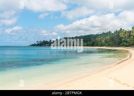 Vista lungo la riva della laguna blu. Una foresta di palme a sinistra, il mare blu tuqruoise a destra. Nanuya laiali. Yasawa Figi Foto Stock